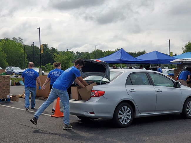 BSNB employee loading food into customer's car trunk